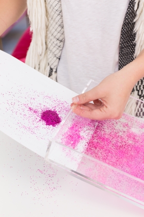 Someone holding a tray of pink glitter