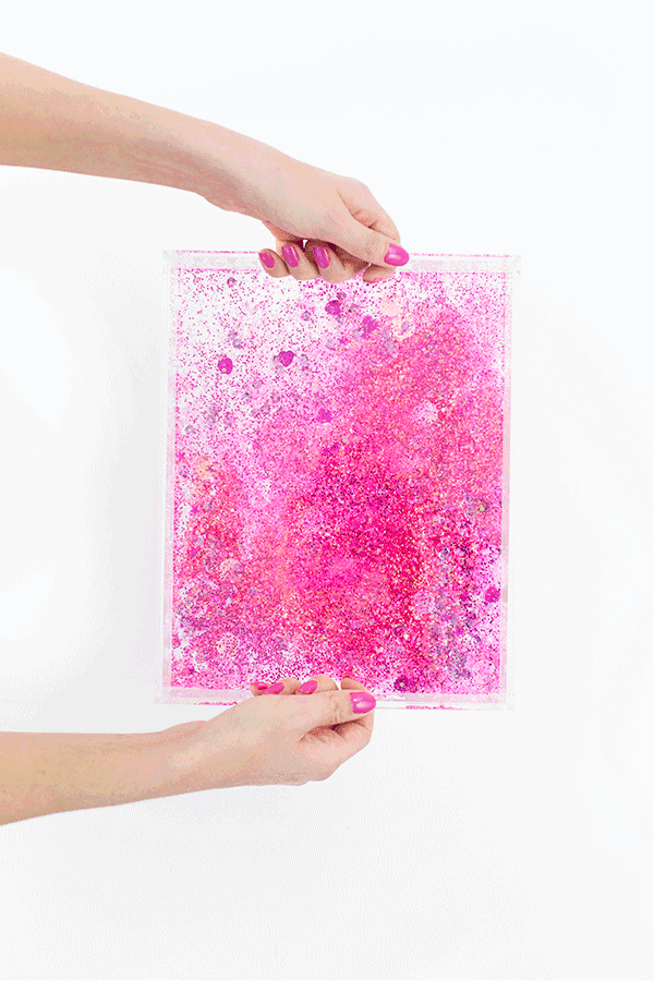 Someone holding a pack of pink glitter