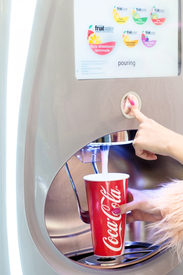 Someone pouring coke into a cup