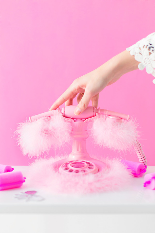 A woman holding a pink phone