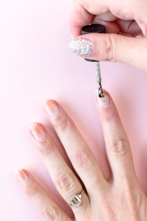 Someone painting their nails silver