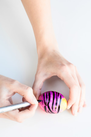 Someone drawing on an egg