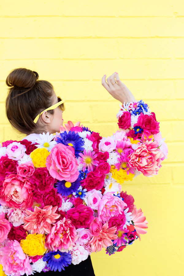 A woman wearing a jacket with flowers on it