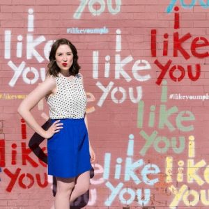 A woman in front of a mural that says "I like you"