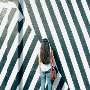 A woman in front of a black and white mural