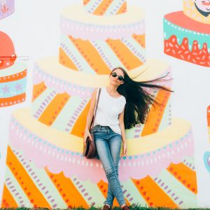 A woman standing in front of a colorful mural