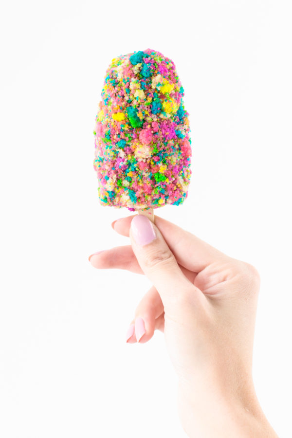 Someone holding a birthday cake popsicle 