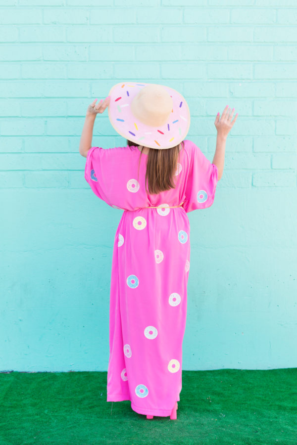 A woman wearing a pink dress with donuts on it