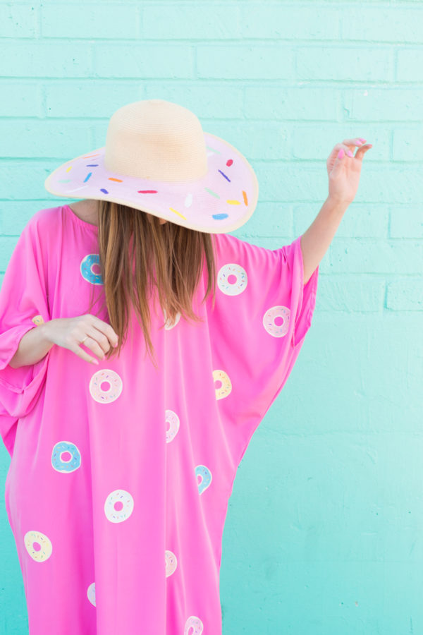 A woman wearing a pink dress with donuts on it