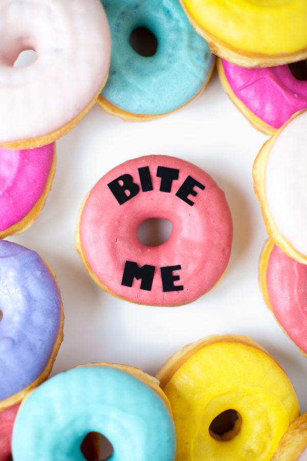 A pink donut that says \"bite me\"