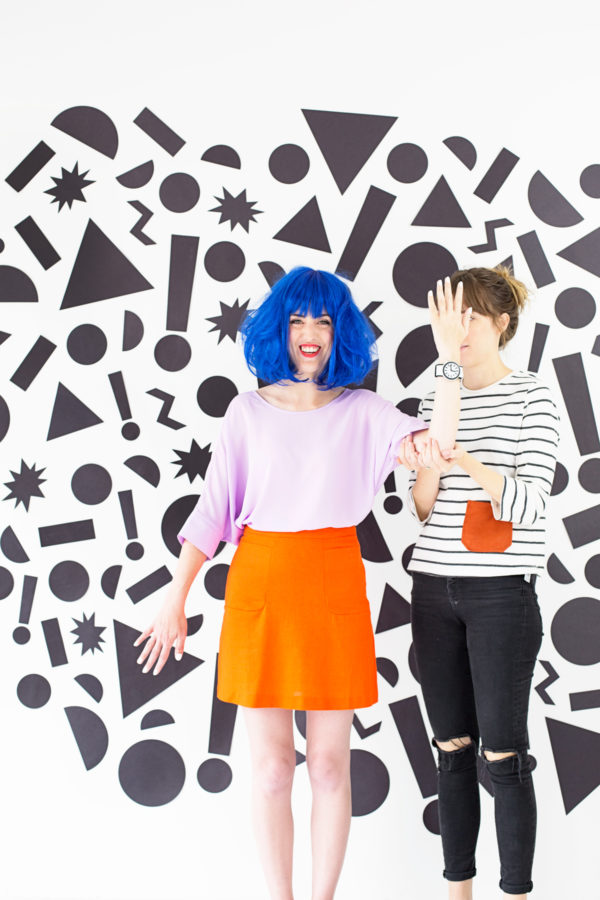 People in front of a wall with black shapes