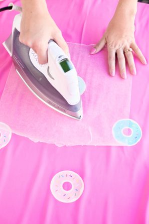 Someone ironing on pink fabric