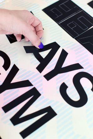 Someone putting black letters on a surface