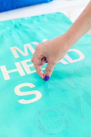 Someone putting letters on aqua fabric