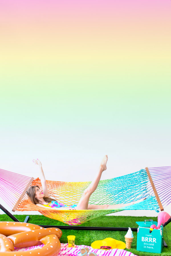 A woman sitting in a rainbow hammock