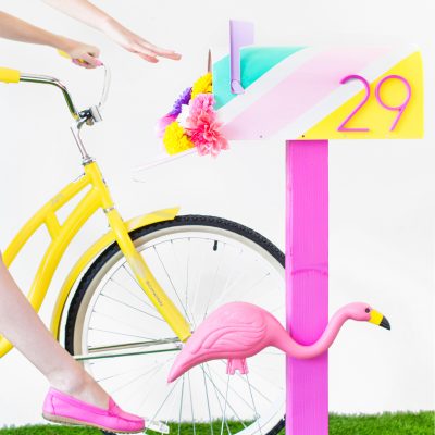 A mailbox with a flamingo and a bicycle 