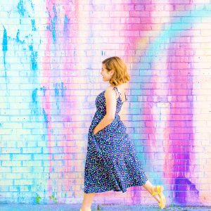 A woman in front of a colorful wall