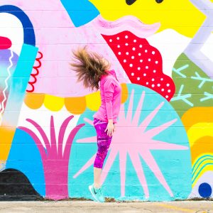 A woman in front of a colorful wall