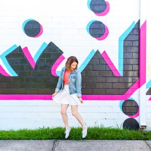A woman in front of a colorful wall