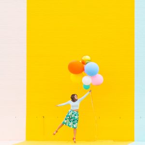 A woman in front of a yellow wall