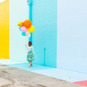 A woman in front of a colorful wall