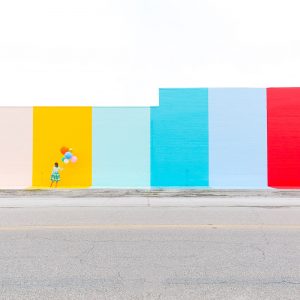 A woman in front of a colorful wall