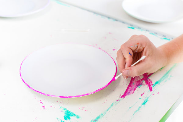 Someone painting a plate