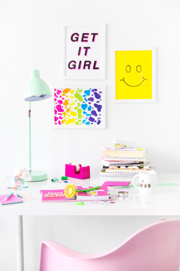 A desk with colorful supplies on it and art on the walls