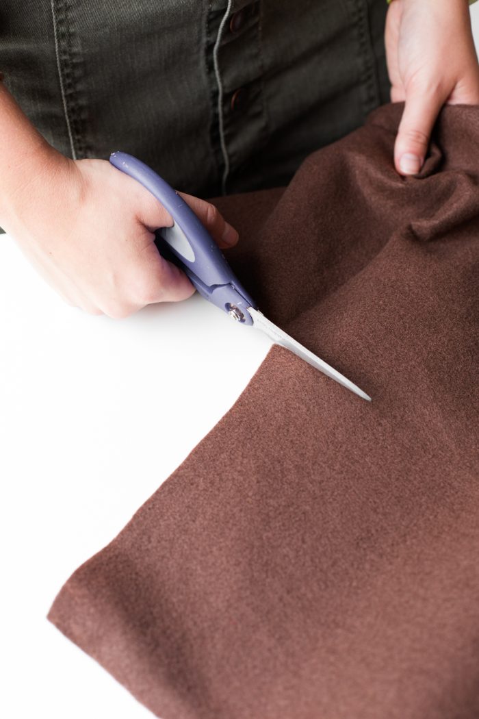 Easy Hot Dog Costume Someone cutting brown fabric with scissors