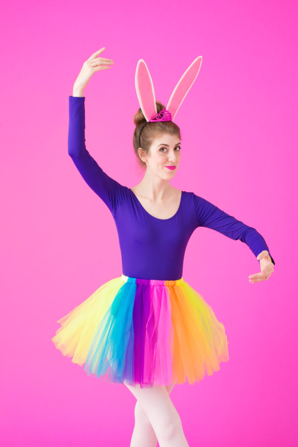 A woman wearing a purple long sleeve and rainbow tutu