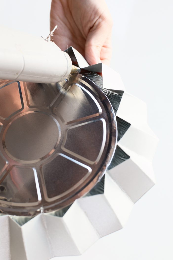 Someone gluing a tin circle