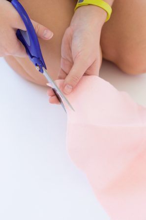 Someone cutting pink fabric
