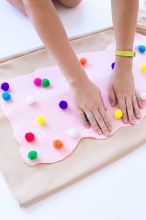 Someone putting pink fabric on beige fabric 