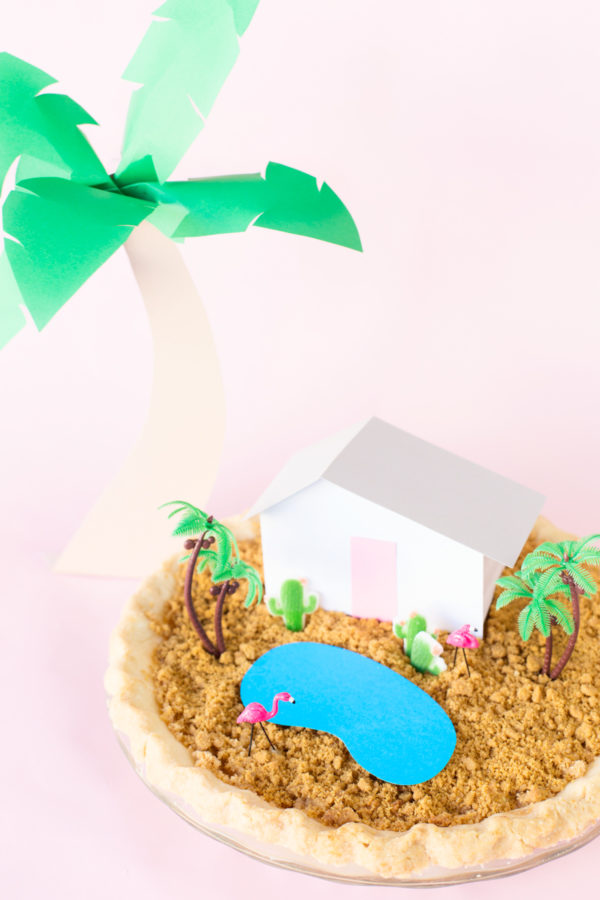 A pie with a miniature house and trees on it