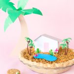 A pie with a mini house and trees on it