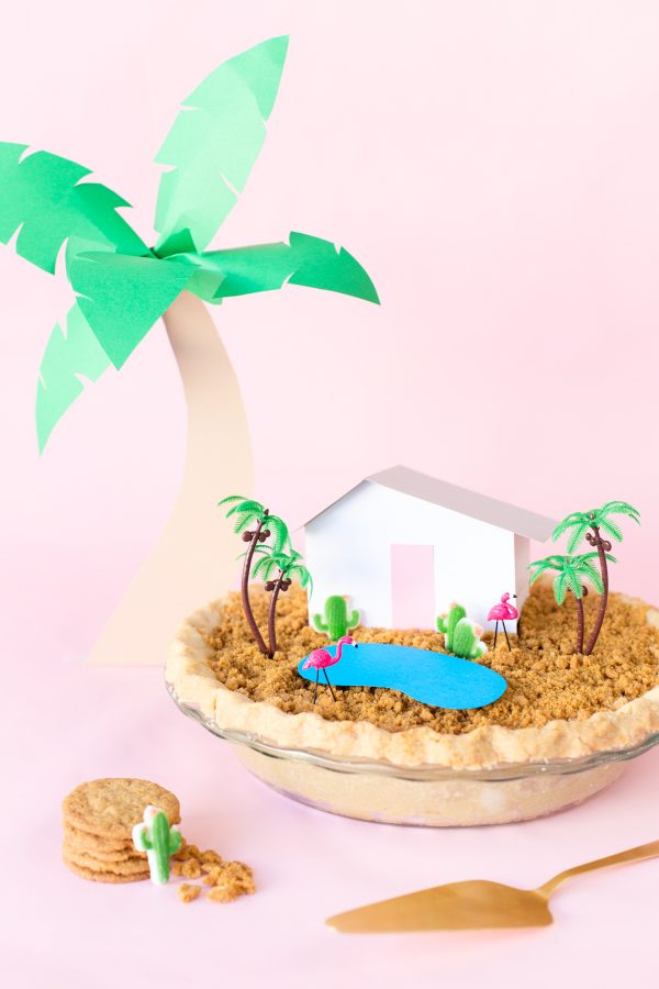 A pie with a mini house and trees on it