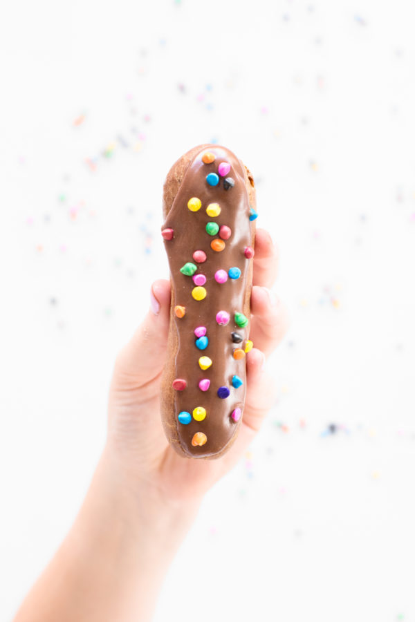 Someone holding a chocolate eclair