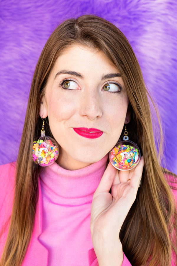 A close-up of a woman wearing confetti earrings