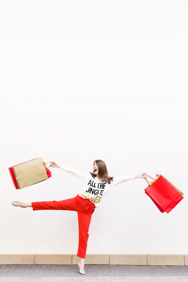 A woman holding red and beige bags