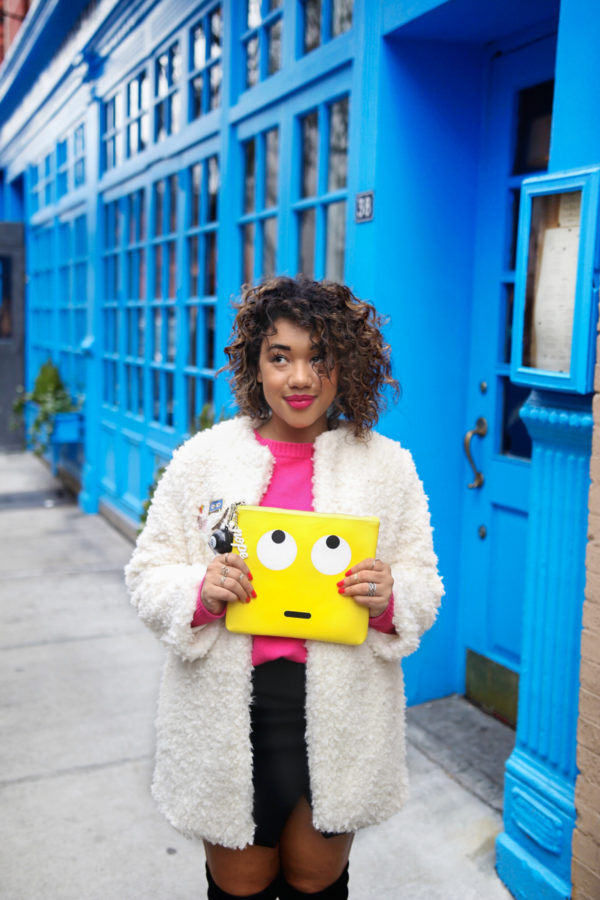 A person holding a yellow clutch