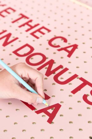 A pink board with red writing on it