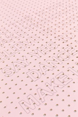 A pink wooden board with holes 