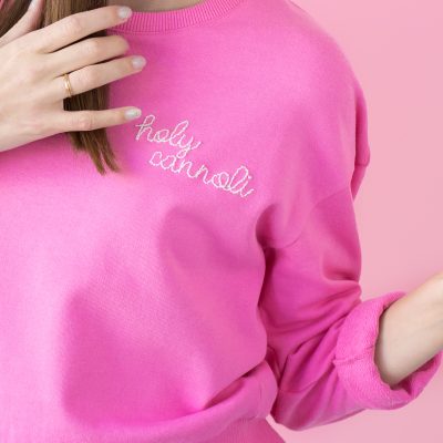 DIY Embroidered Sweatshirt (+ My Fave Easy Embroidery Hack!!) The corner of a pink crew neck with embroidered words on it