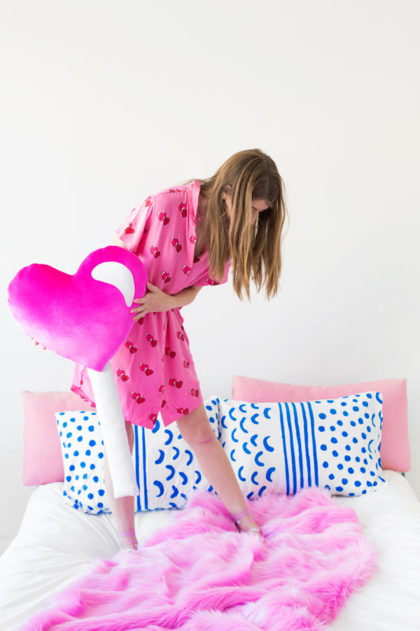 A woman holding a heart pillow