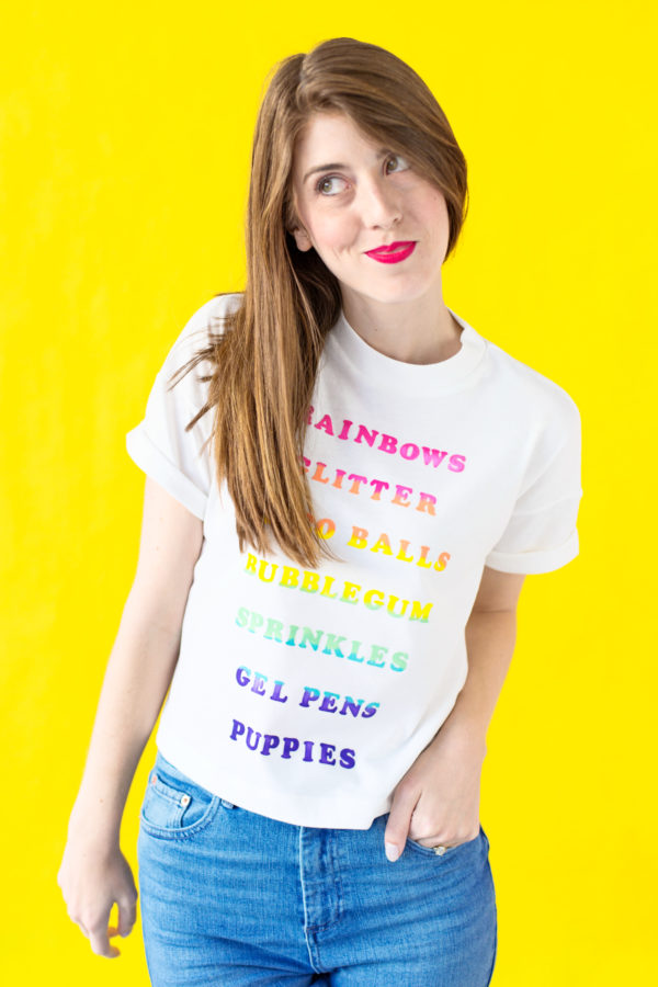 A woman wearing a shirt with rainbow words