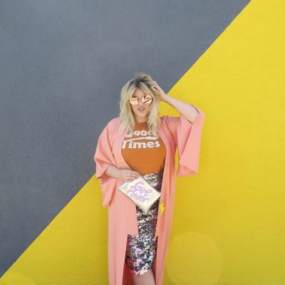 What's In My Clutch: Alex Michael May A person wearing clothes in front of a grey and yellow wall