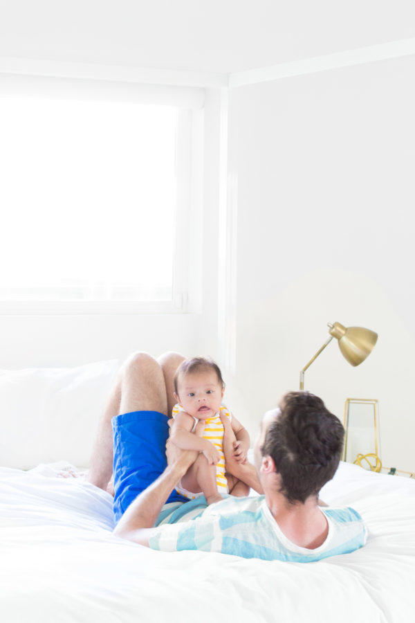 Someone holding a baby on a bed