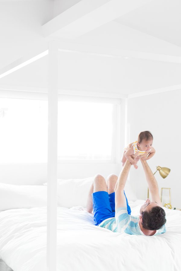Someone holding a baby on a bed