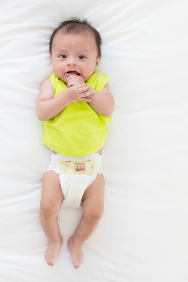 A baby sitting on a bed