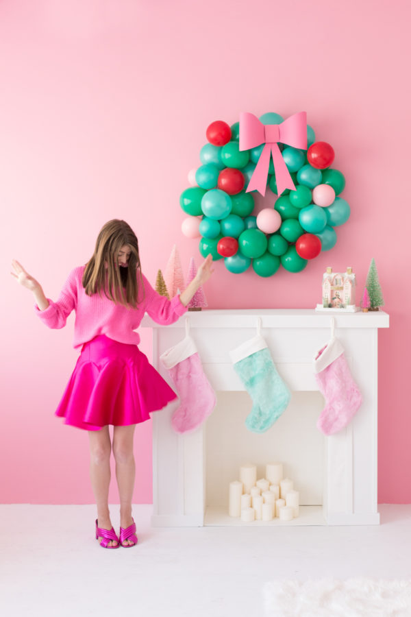 A girl in a pink dress next to a fire place